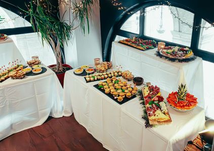 Buffet table with assorted appetizers and fruit platters in a bright dining room