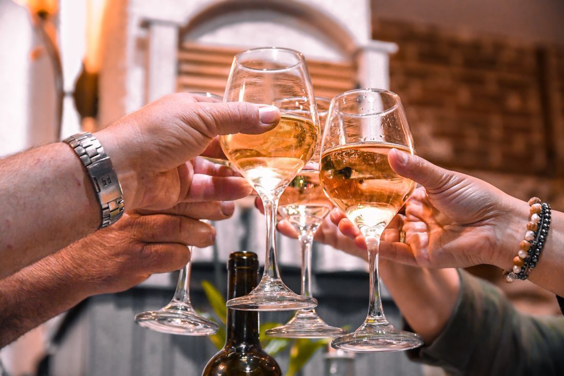 Hands toasting with champagne glasses at a festive outdoor gathering
