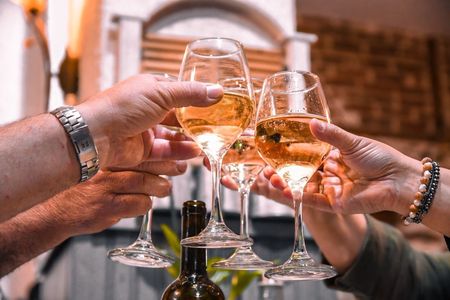 Hands toasting with champagne glasses at a festive outdoor gathering