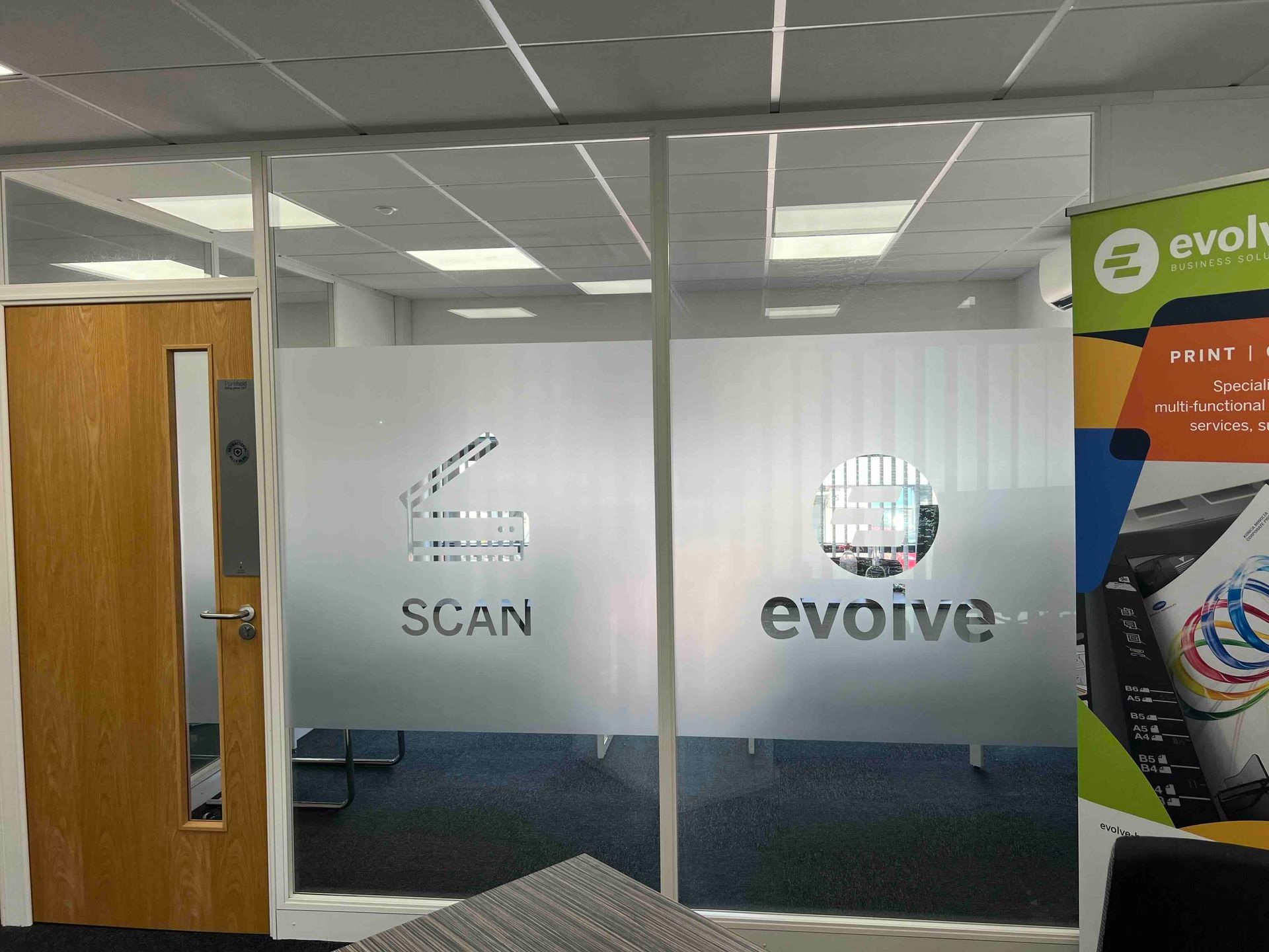 Frosted glass manifestations with cut-out logos on office partition
