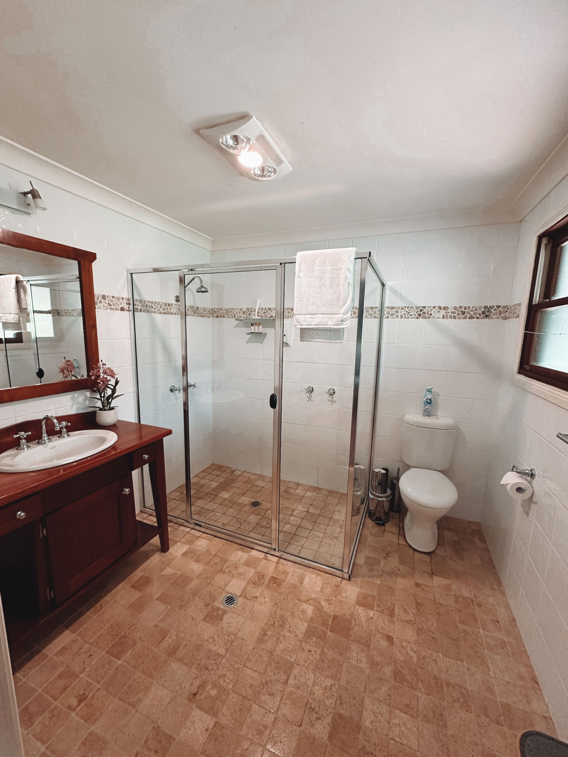 Bathroom with brown vanity, shower, toilet, and tiled floor — Integral Cleaning Services in Aberdare, NSW