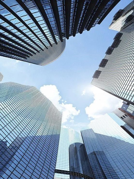 Looking up at a group of skyscrapers with a blue sky in the background