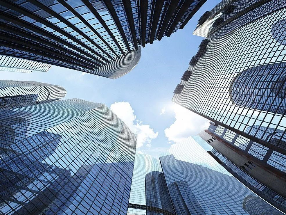 Looking up at a group of skyscrapers in a city.