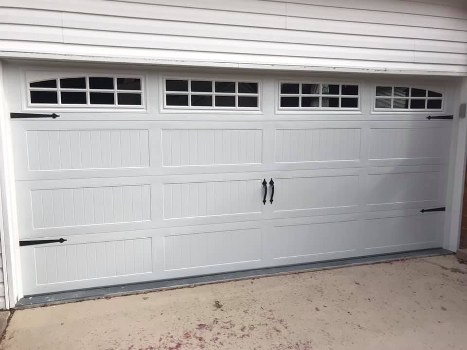 A white garage door with black handles and windows