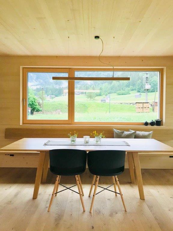 Ein Esszimmer mit Tisch und Stühlen und einem großen Fenster