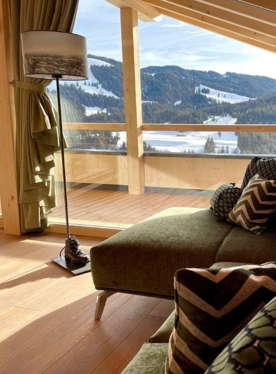 Ein Wohnzimmer mit einer Couch und einer Lampe und Blick auf die Berge.