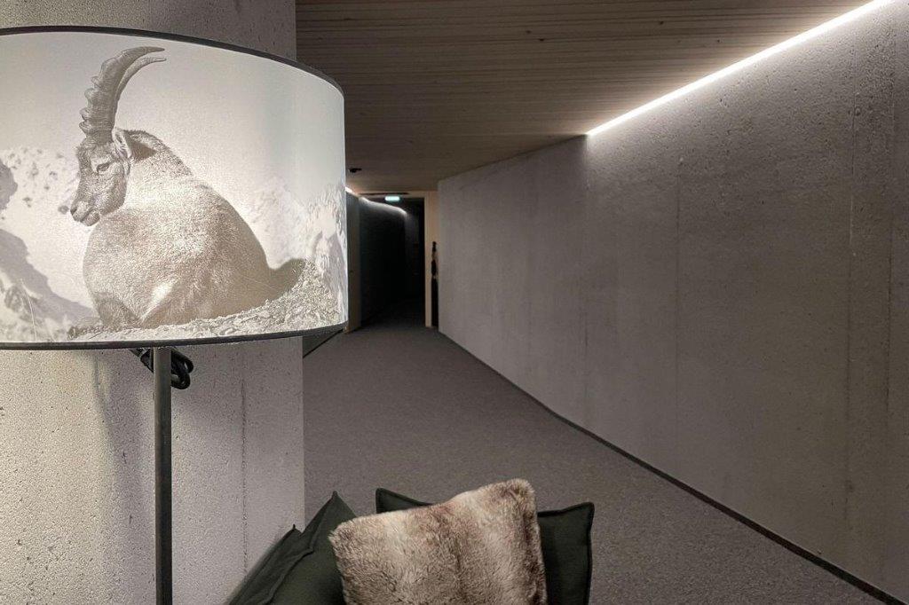Eine Lampe mit dem Bild einer Ziege steht in einem Flur neben einem Sofa.