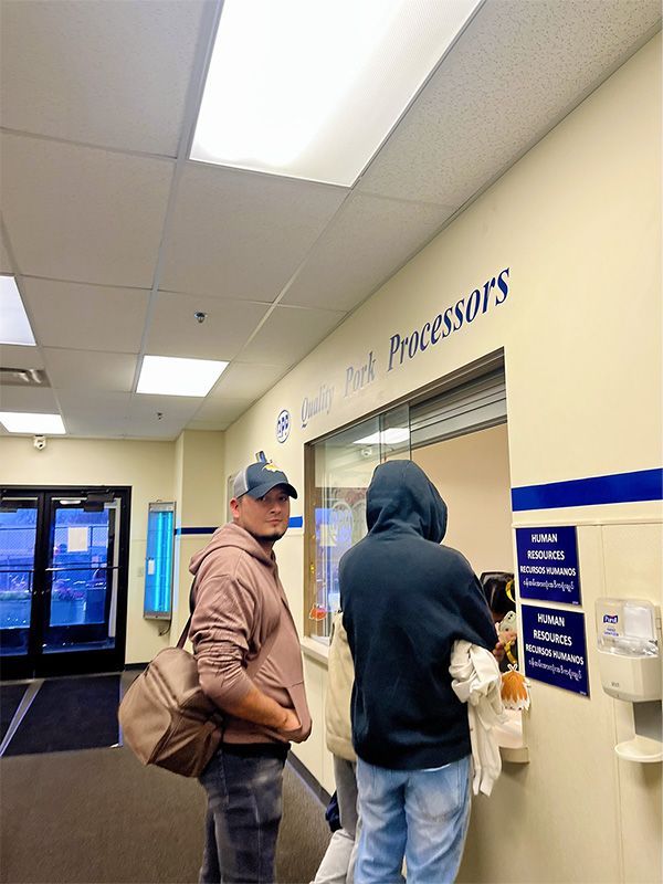 Two people stand at a service window labeled 