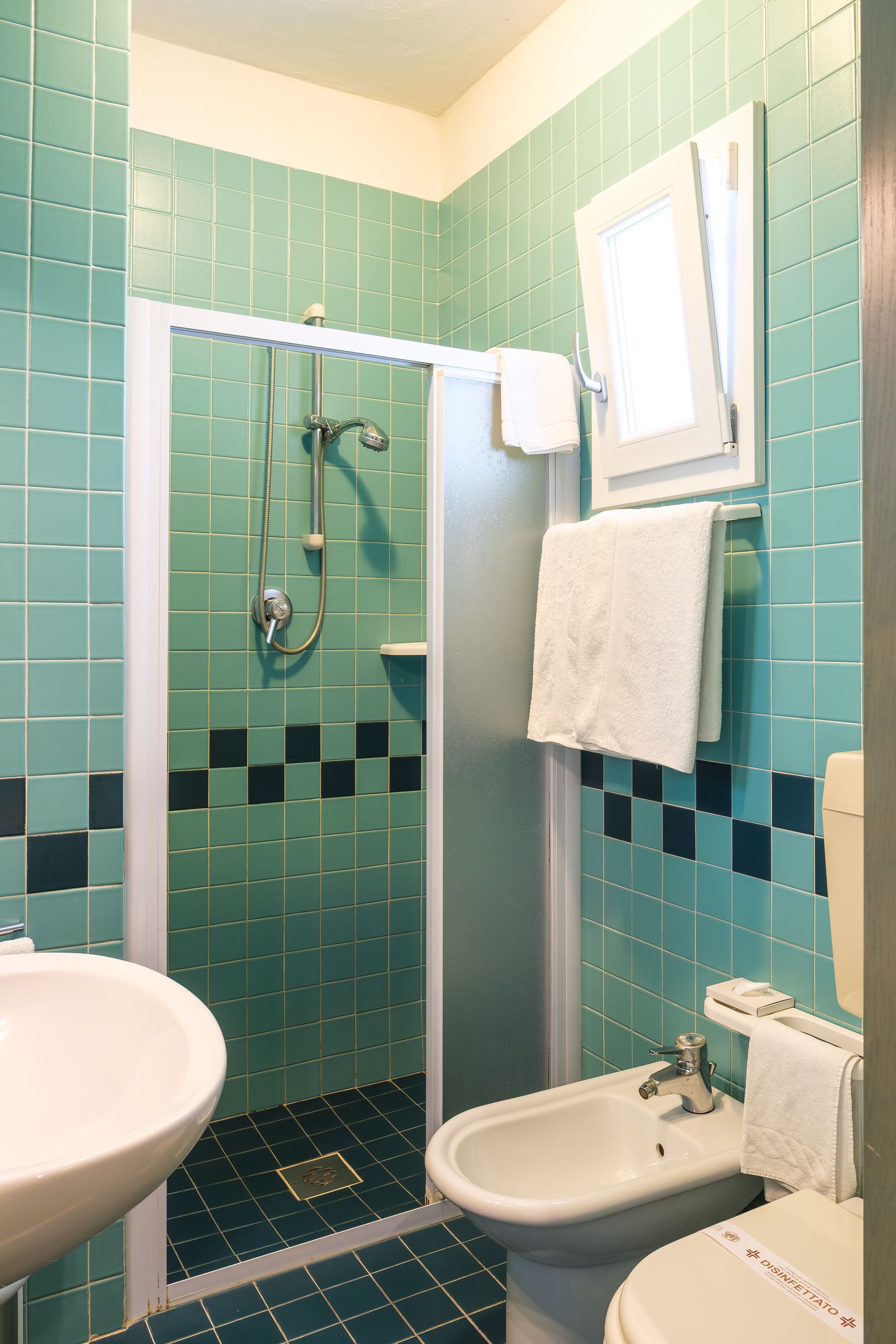 Un bagno con lavandino, water e doccia.