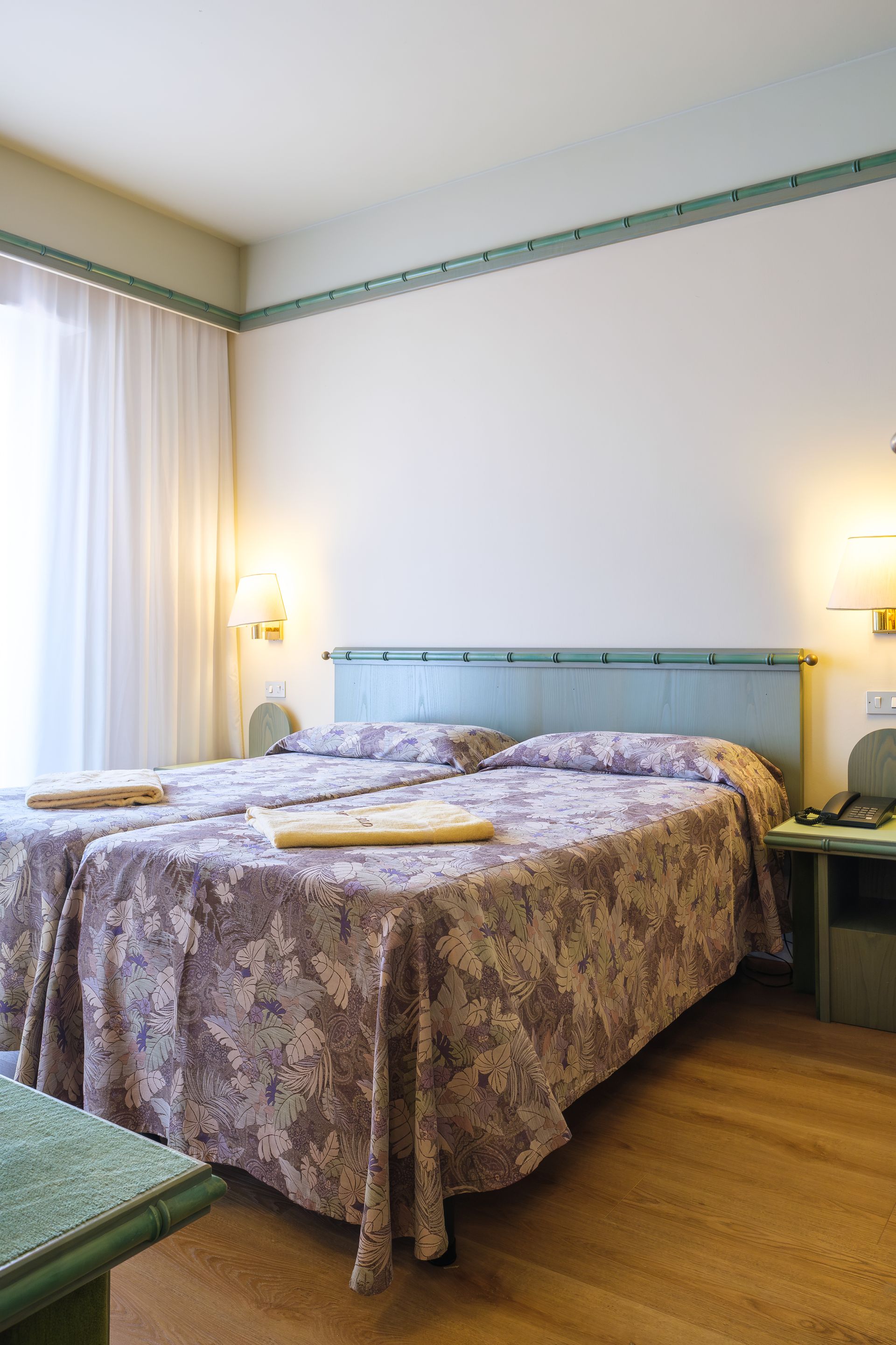 Una camera d'albergo con due letti e un tavolo.