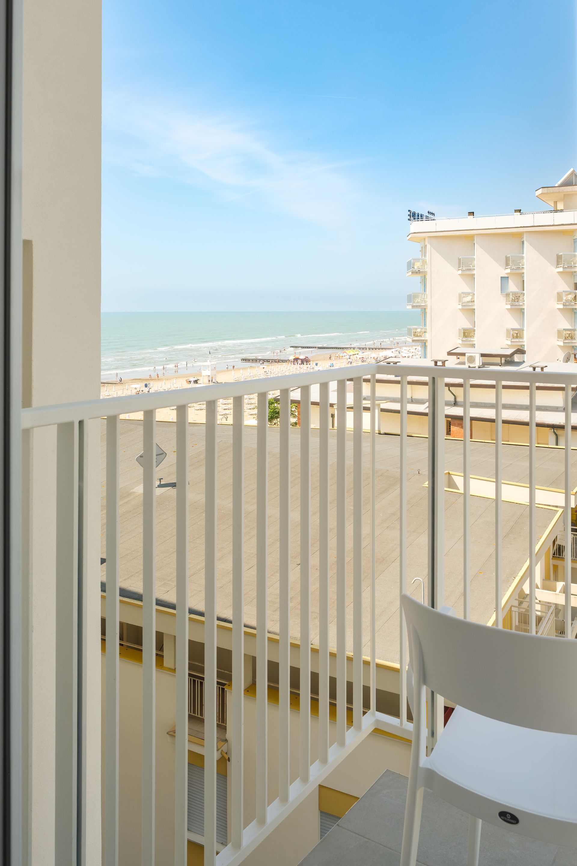 Un balcone con vista sul mare e sugli edifici.
