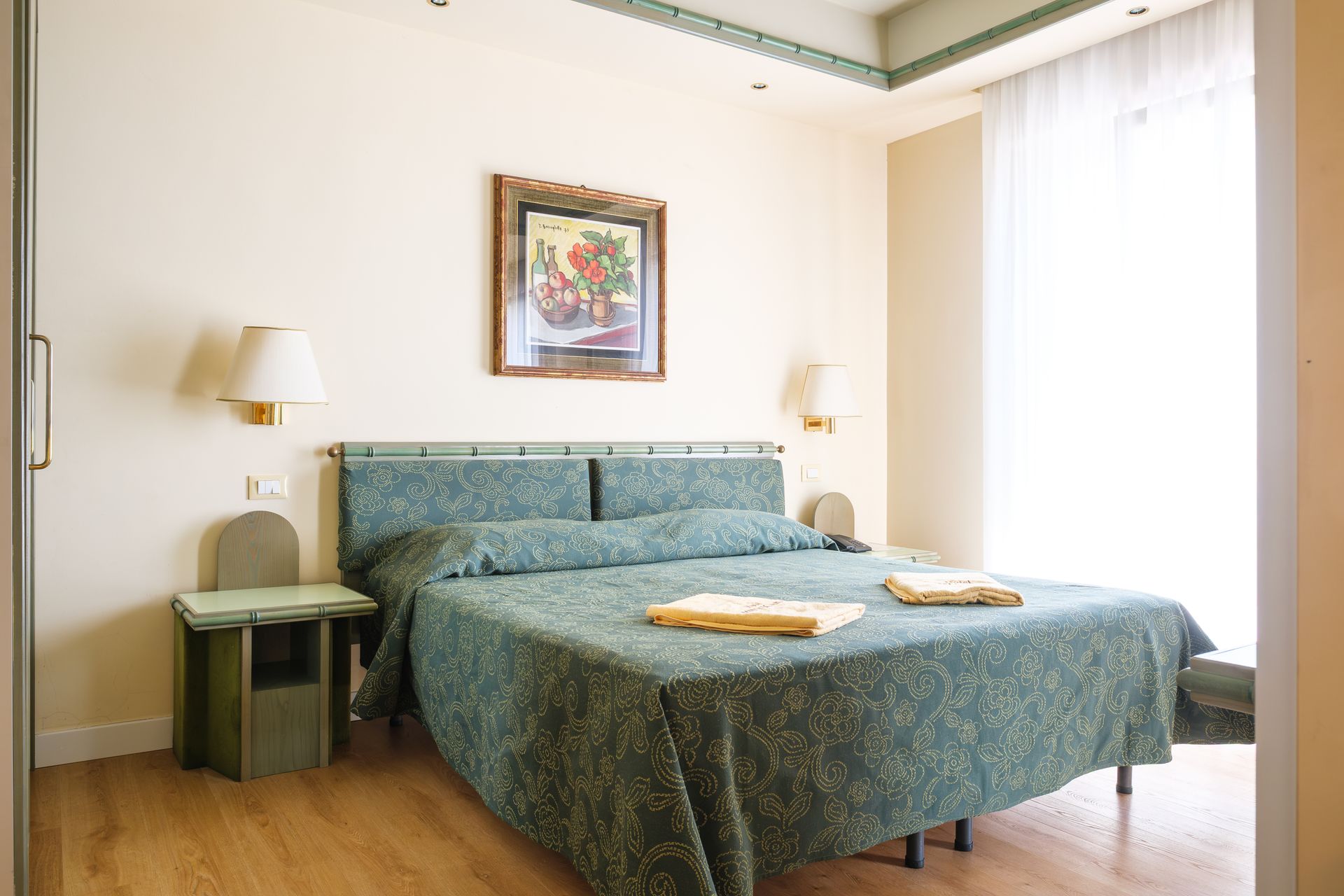 Una camera d'albergo con un letto grande e un quadro alla parete.