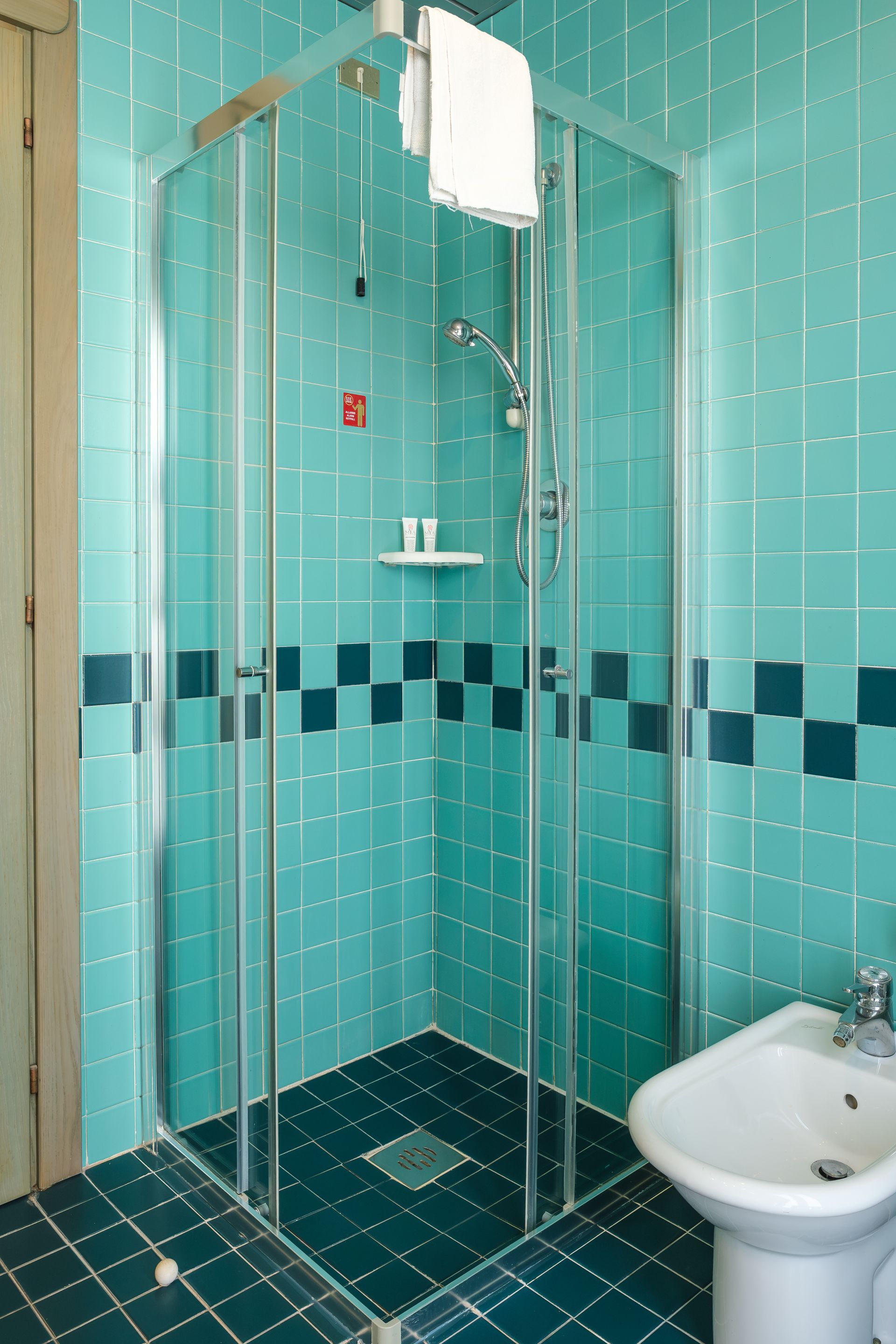 Un bagno con piastrelle blu e cabina doccia.