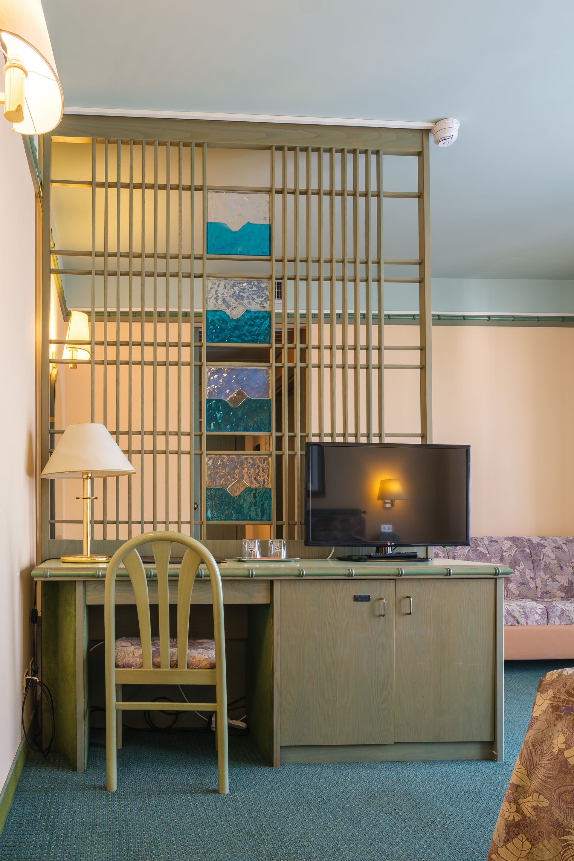 Una stanza d'albergo con una scrivania, una sedia e una televisione.