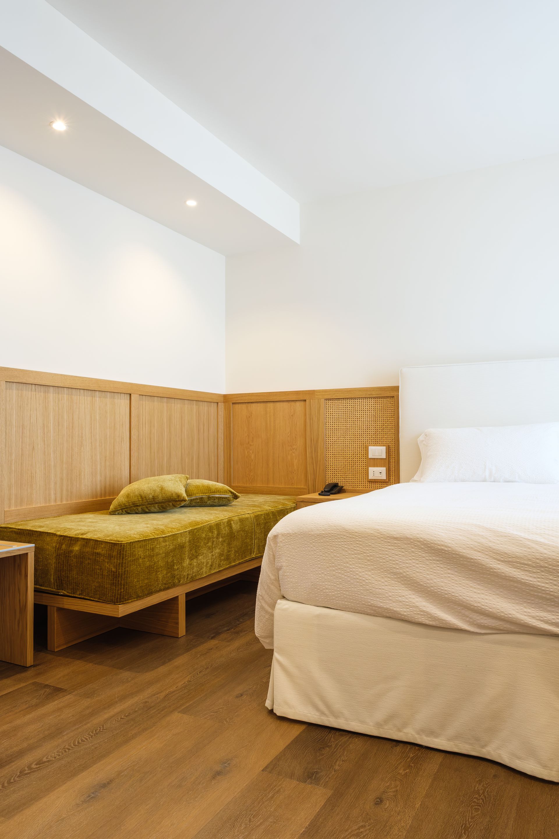 Una camera d'albergo con due letti e un letto grande.