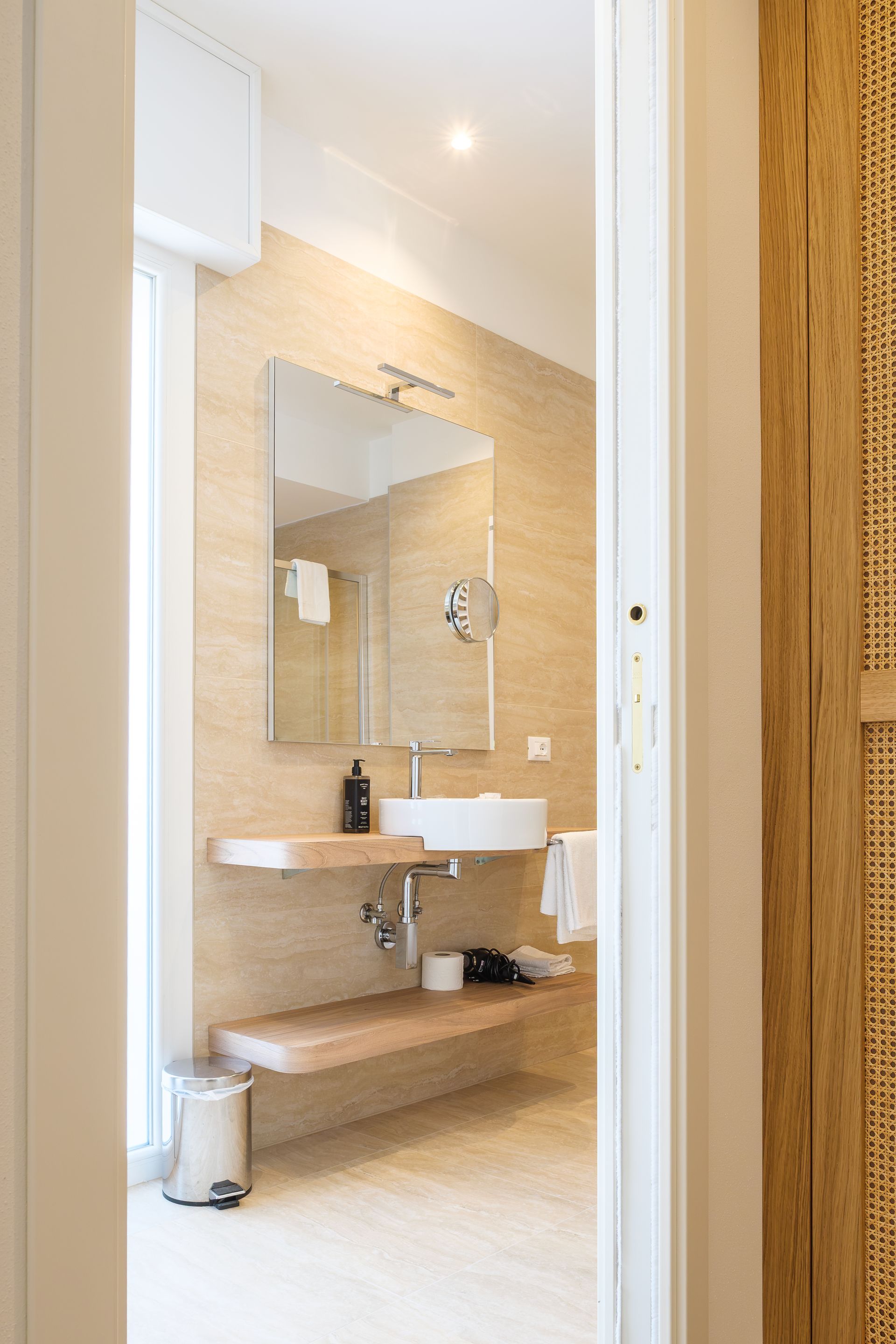 Un bagno con lavandino, specchio e mensola.