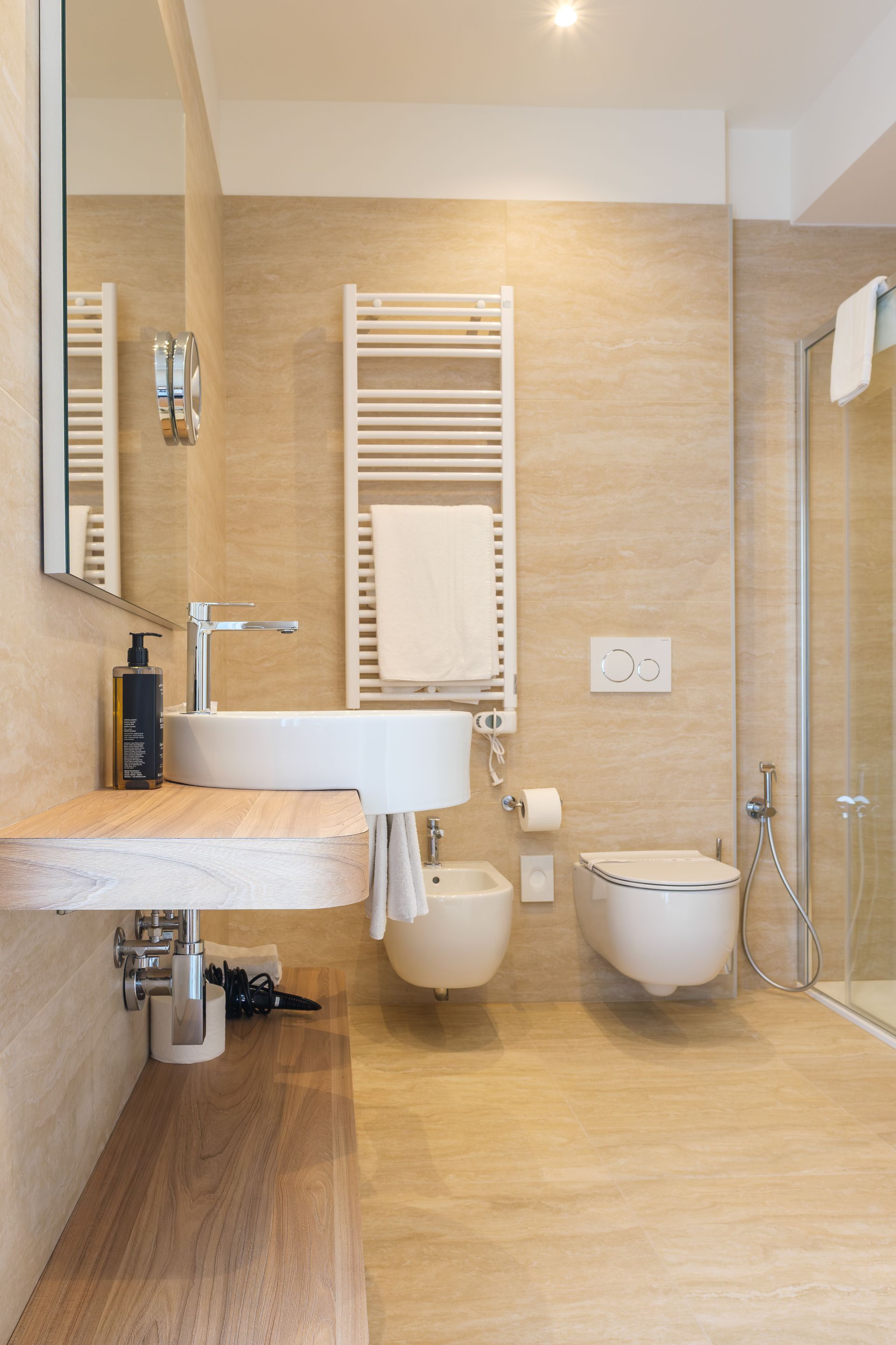 Un bagno con lavandino, water, bidet e doccia.