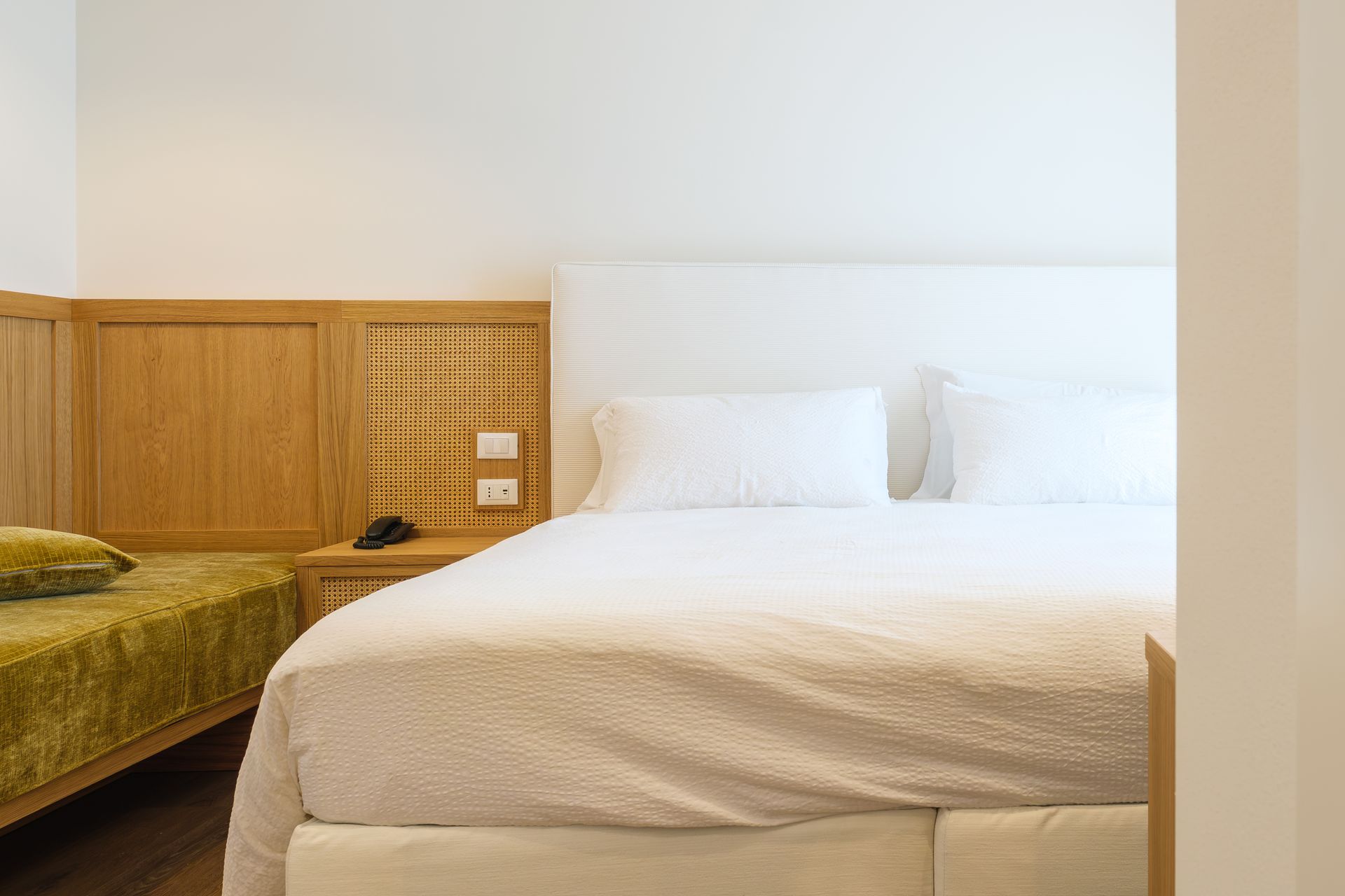 Una camera d'albergo con un letto grande e due letti piccoli.