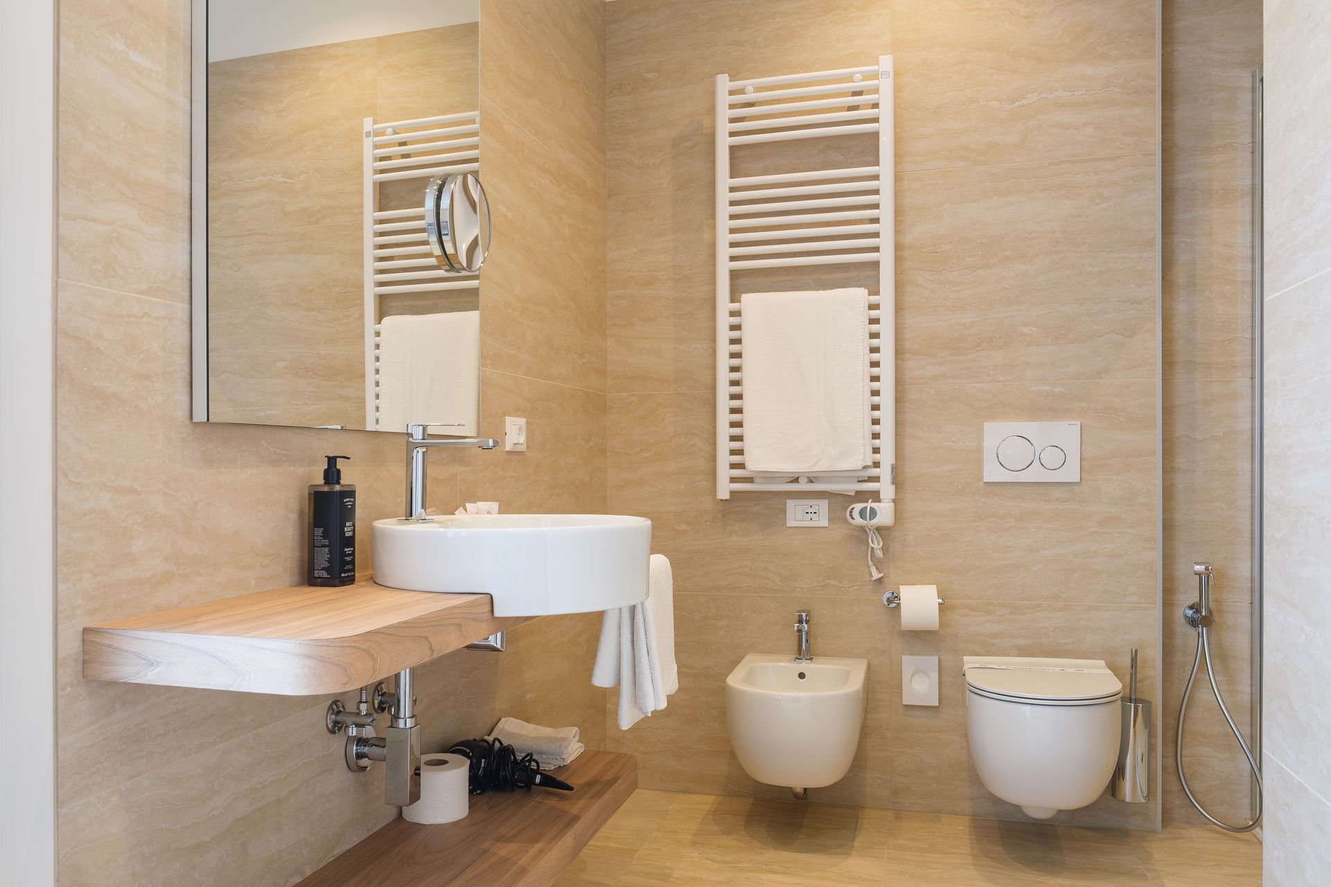 Un bagno con lavandino, WC e specchio.