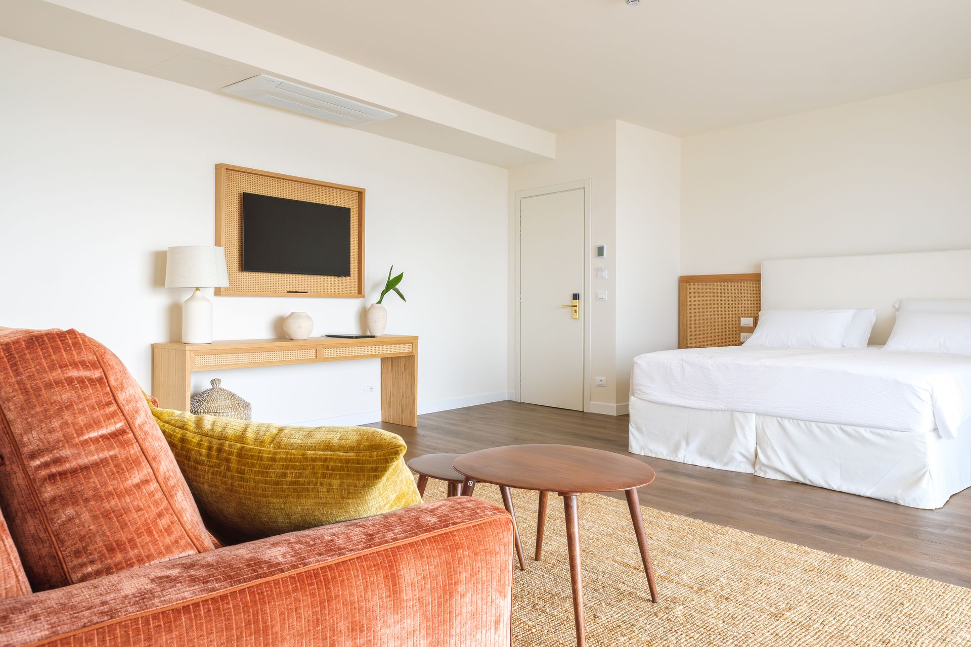 Un soggiorno con divano, sedia, tavolo e letto.