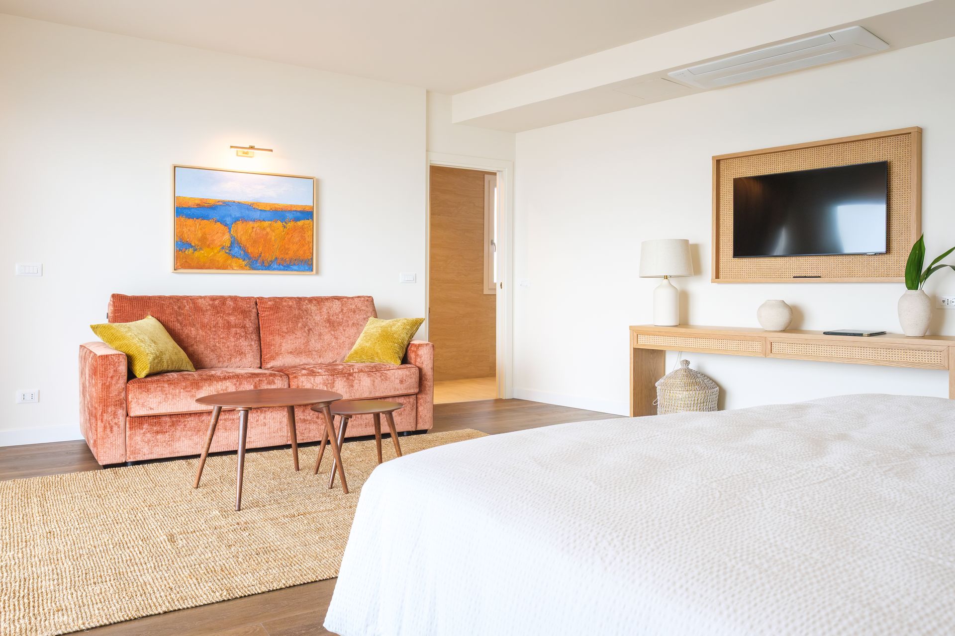 Una camera da letto con un letto, un divano, un tavolo e una televisione.