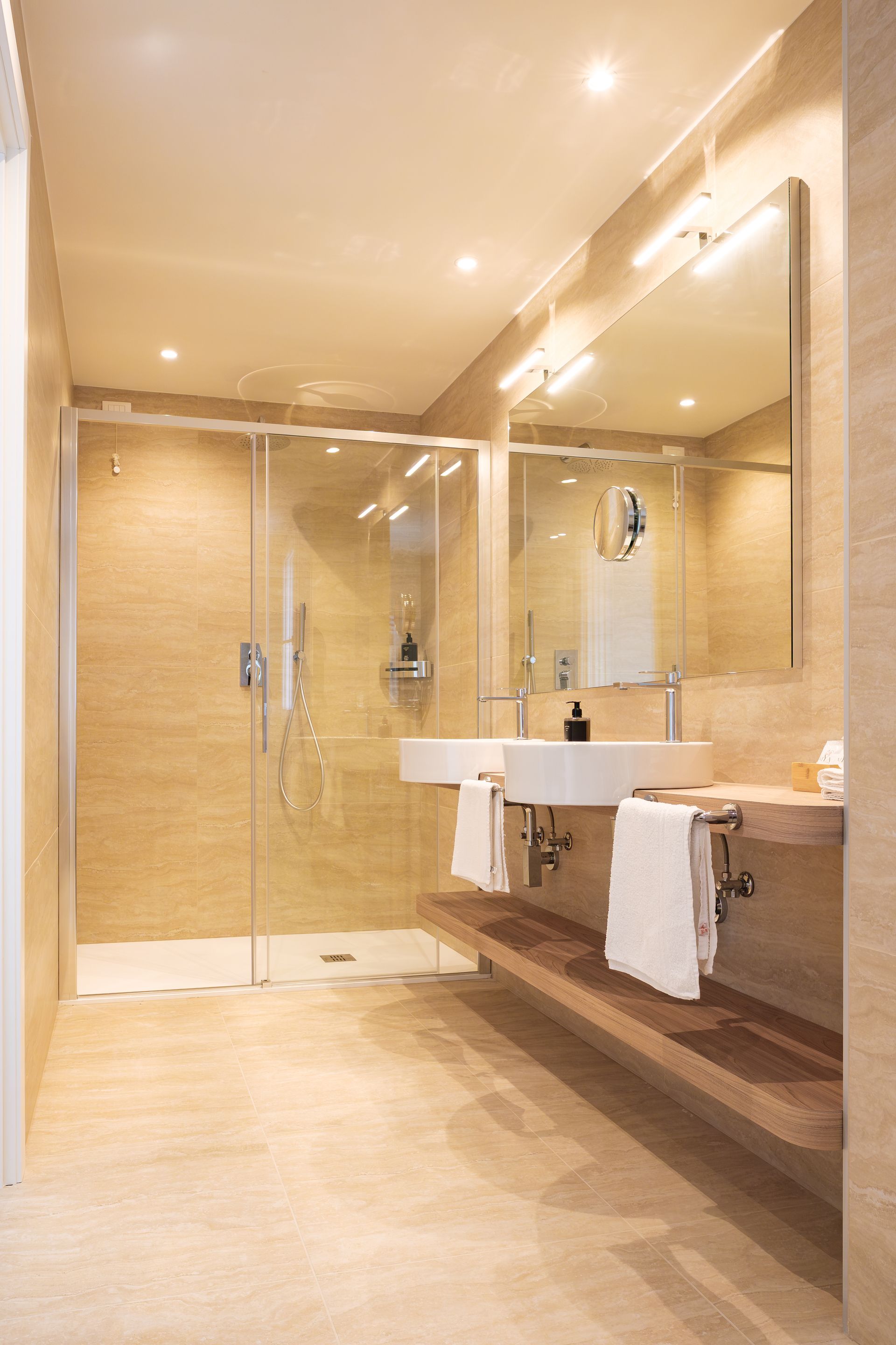 Un bagno con due lavandini e una cabina doccia.