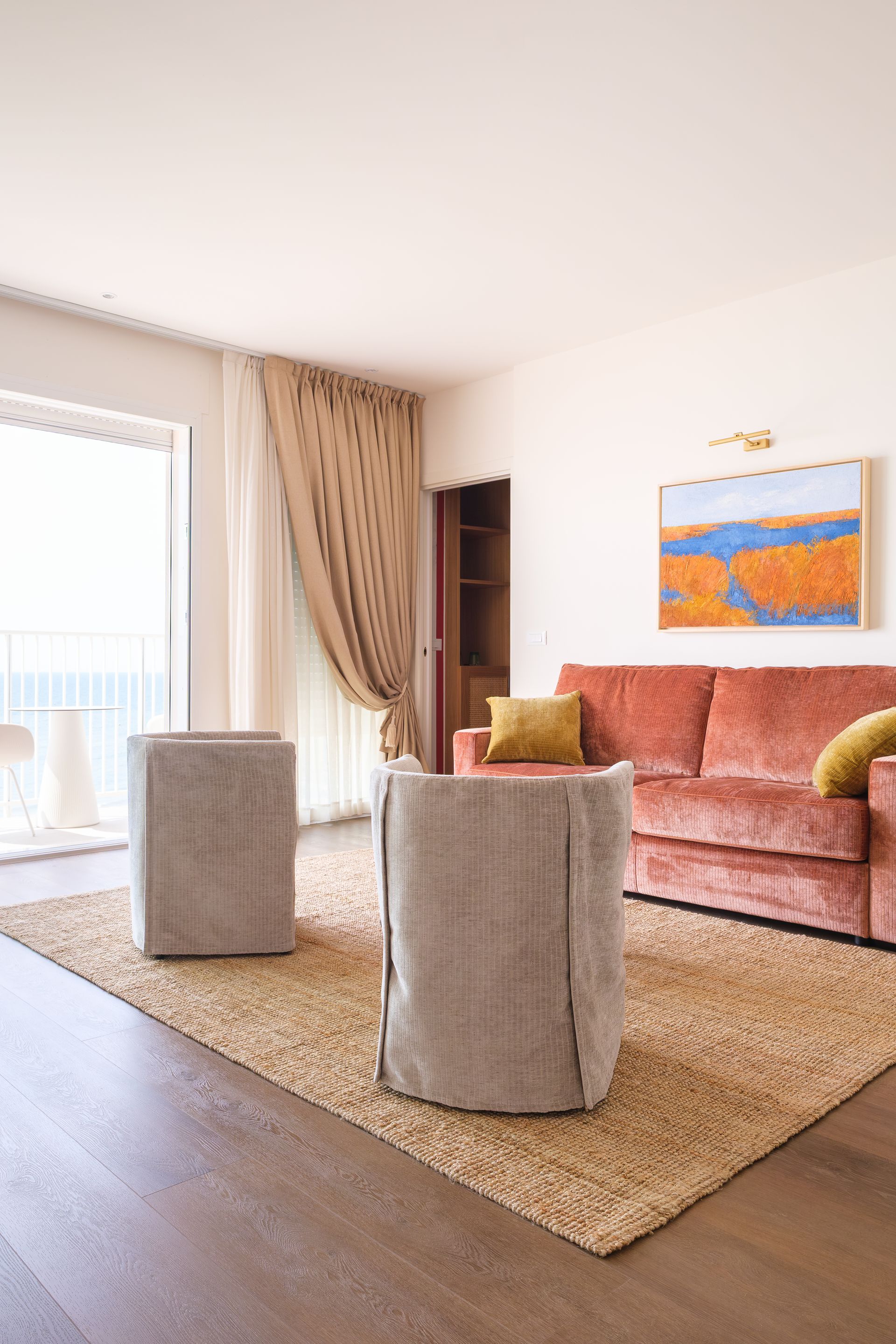 A living room with a couch, chairs and a rug.