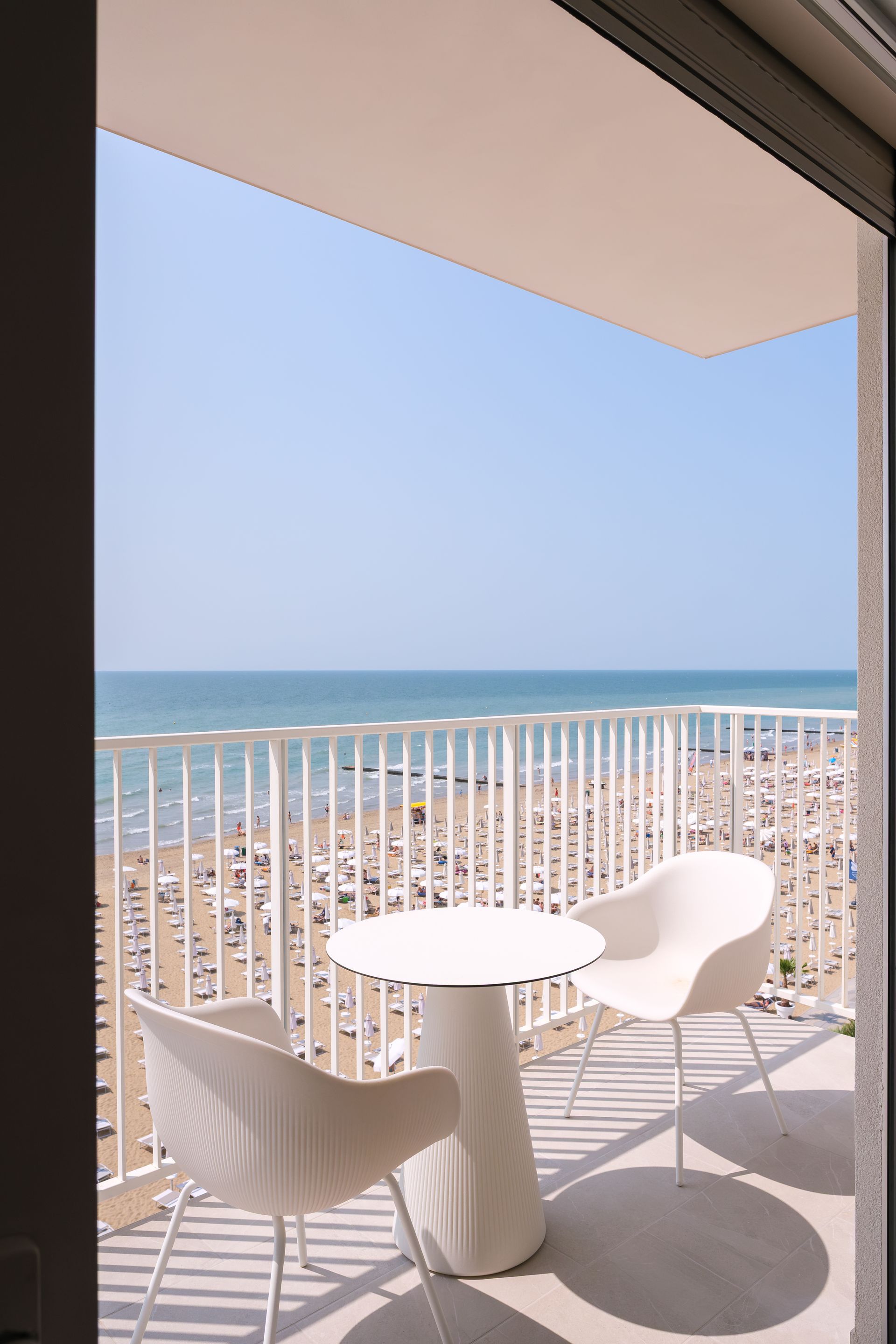 Un balcone con tavolo e sedie con vista sul mare.