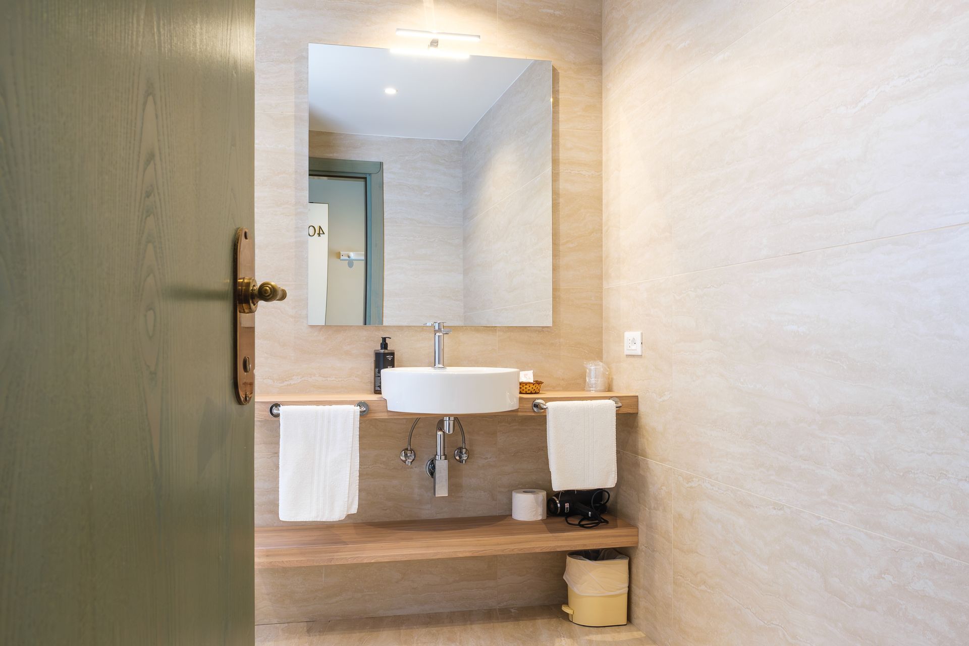 Un bagno con lavandino, specchio e asciugamani.