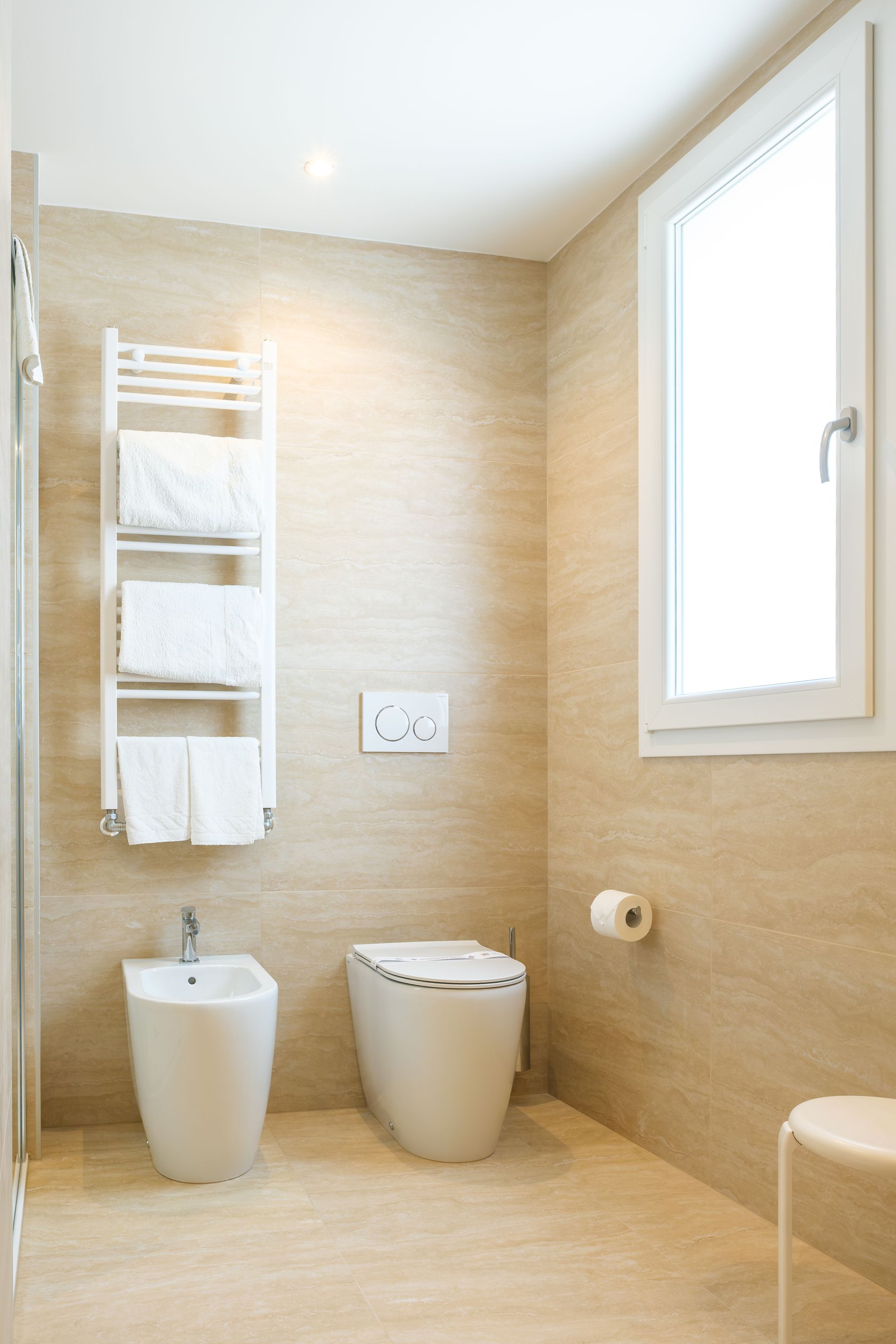 Un bagno con due wc, un bidet e una finestra.