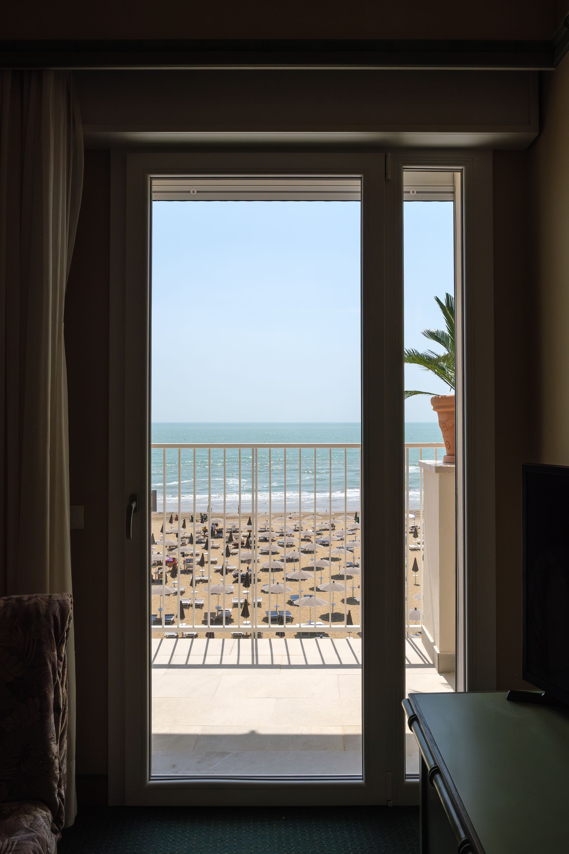 Una camera con balcone e vista sul mare.