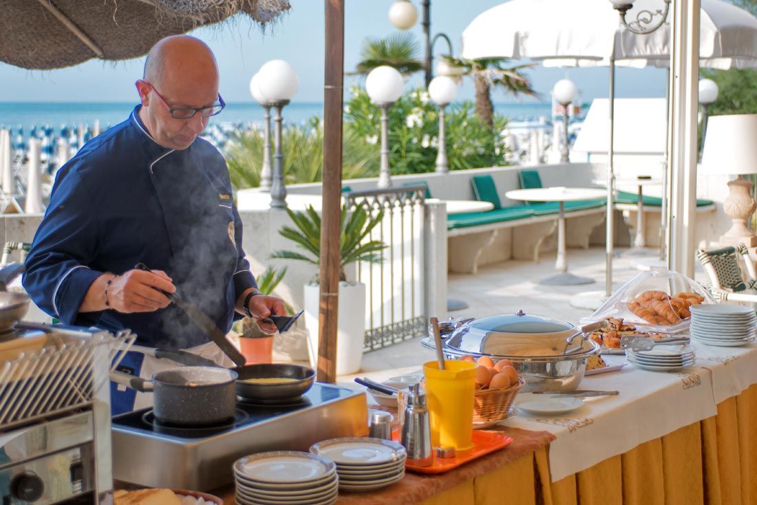 Ein Mann kocht Essen in einer Pfanne auf einem Herd.