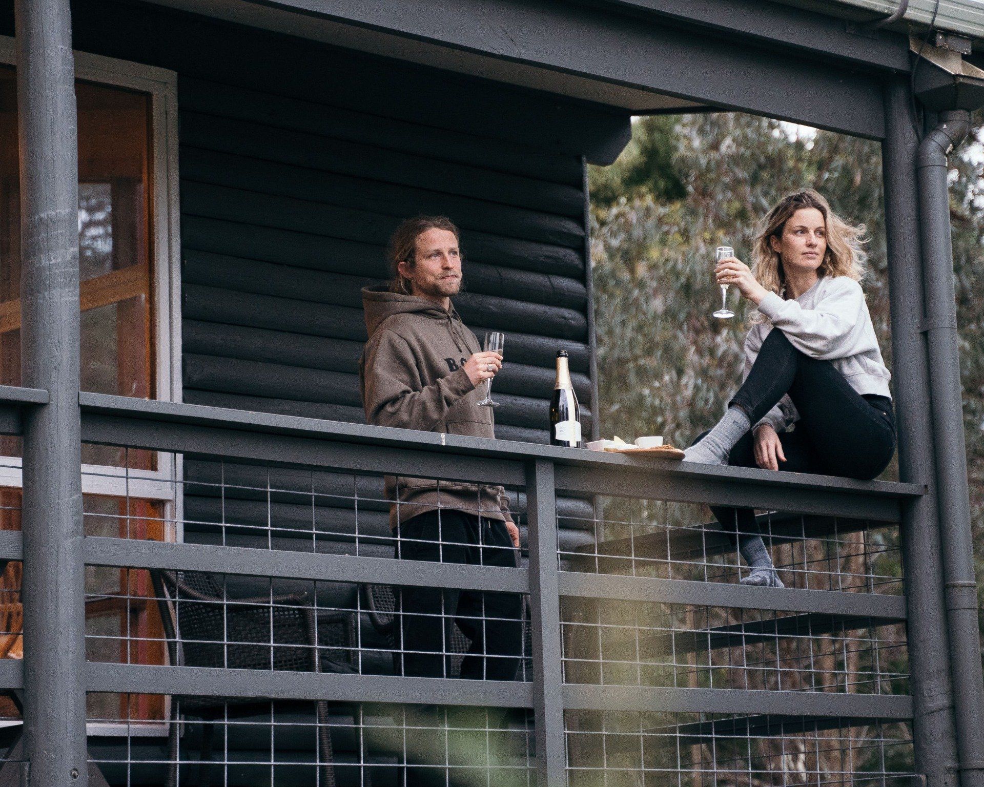Guest celebrating on the balcony of Cape Cottage surrounded by Otway bushland