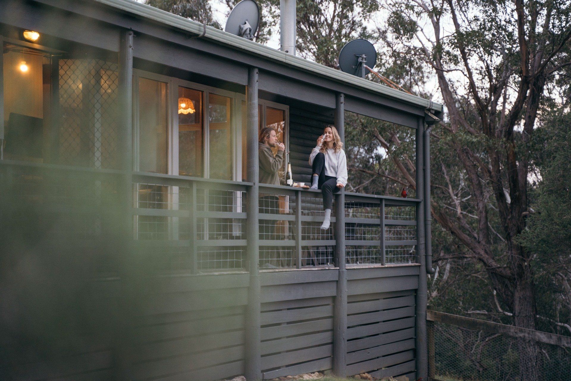 Guest standing on the balcony of Cape Cottage surrounded by Otway bushland