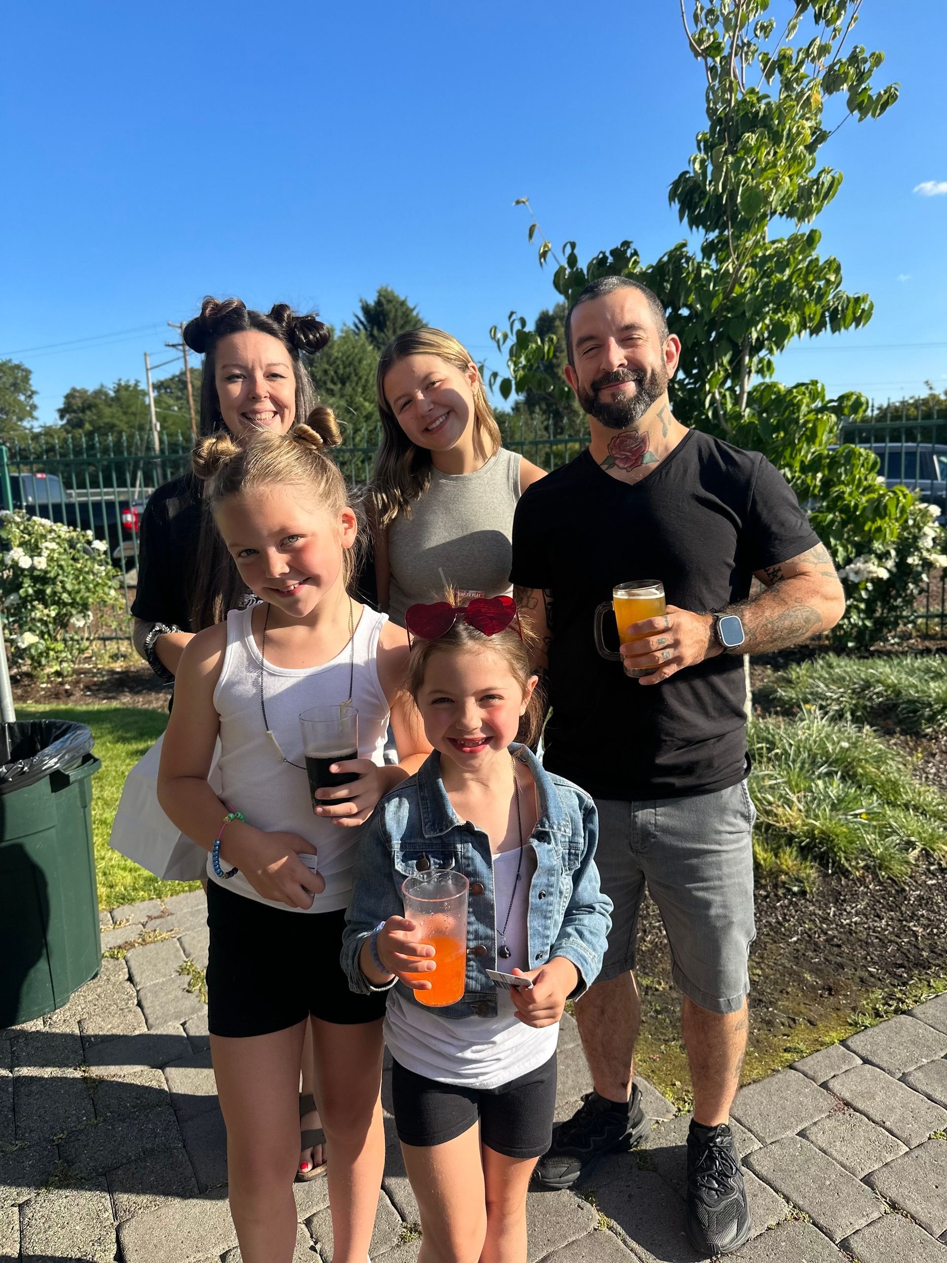 A group of people standing next to each other holding drinks. A group of people standing next to each other holding drinks.