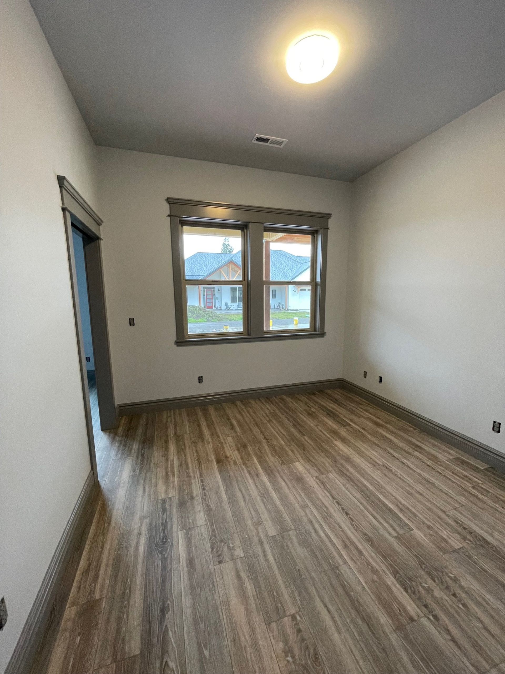 An empty room with hardwood floors and two windows. An empty room with hardwood floors and two windows.