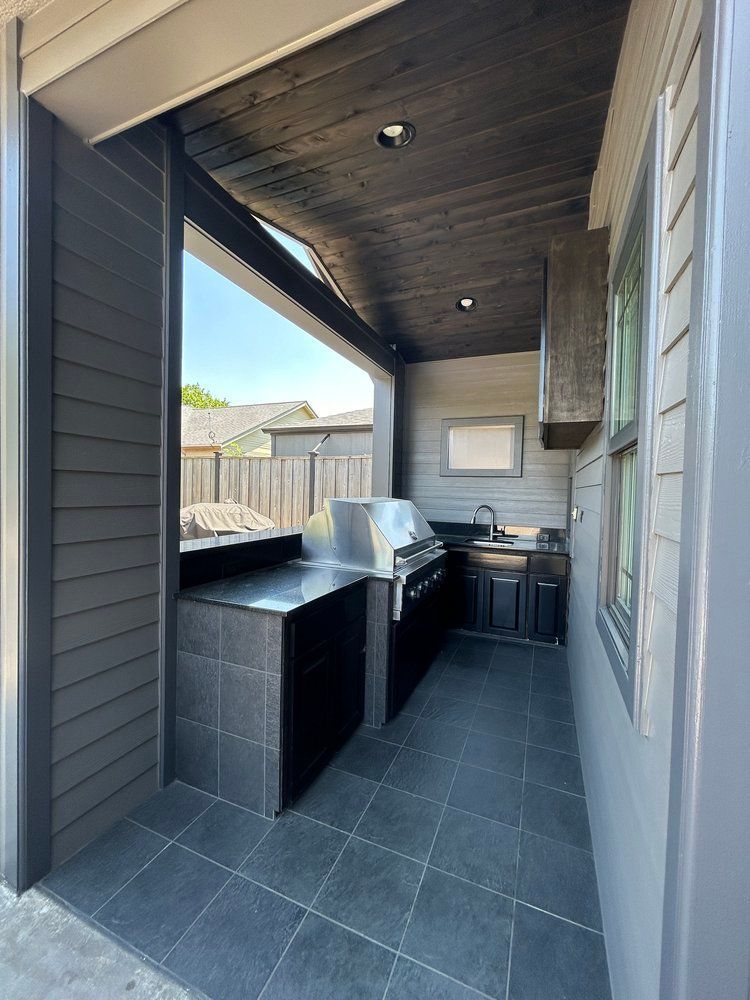 An outdoor kitchen with a grill and a sink