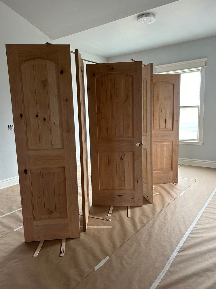 A room with a lot of wooden doors and a window.