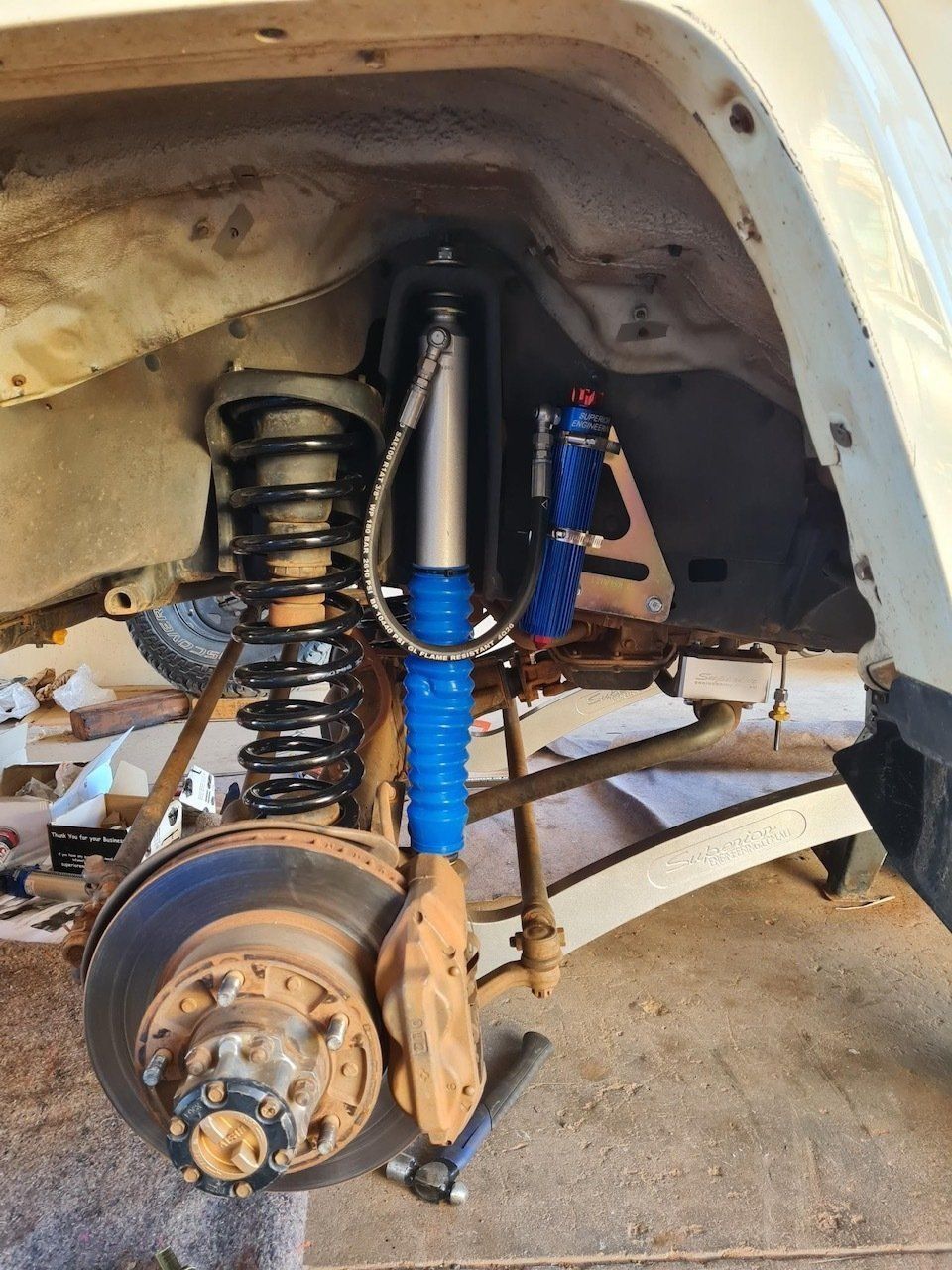 Car Suspension System with Blue Shocks and Black Coil Spring — Central Australian Sidelifter Haulage in Ciccone, NT