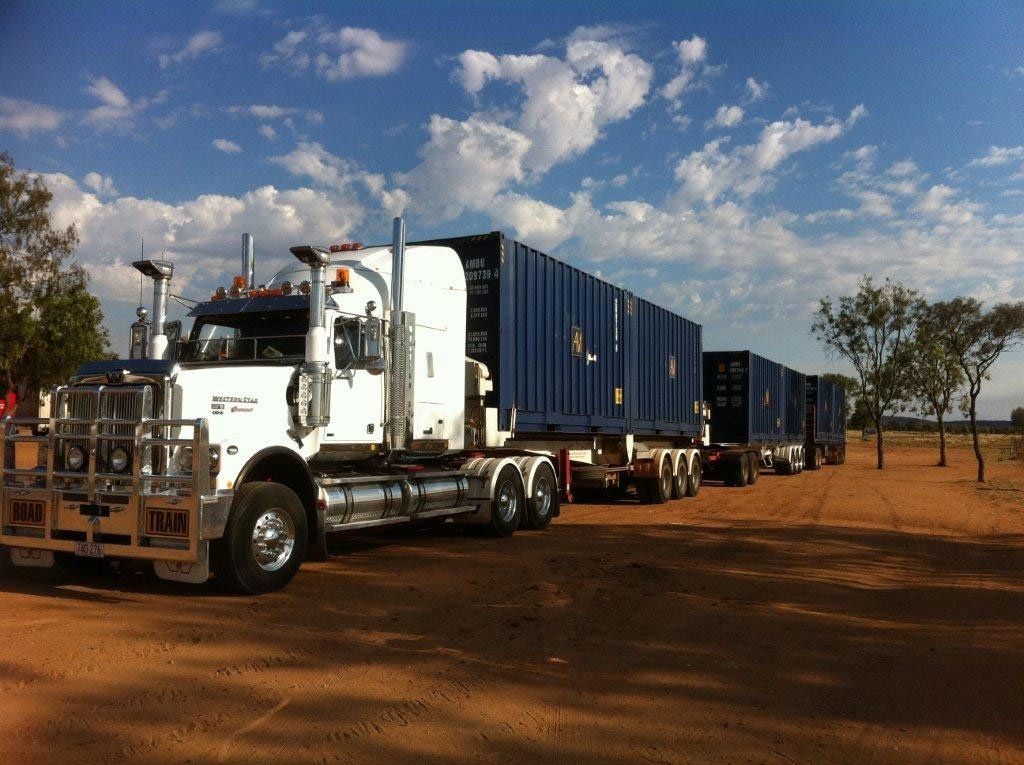 White Semi-Truck Hauling Multiple Blue Shipping Containers — Central Australian Sidelifter Haulage in Ciccone, NT