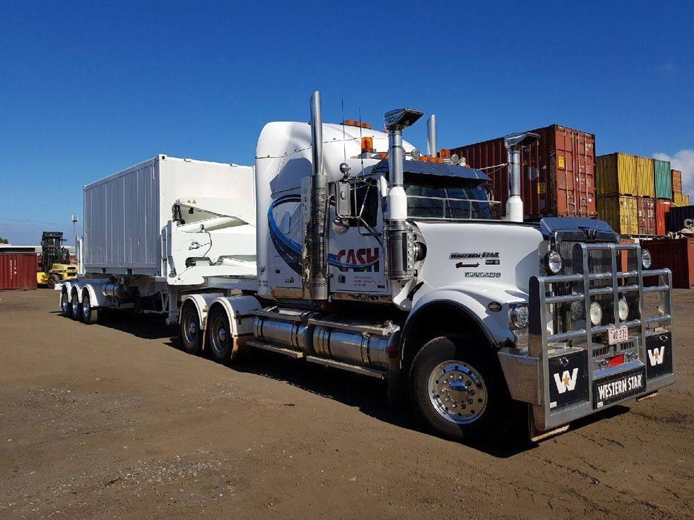 White Semi-Truck with Trailer Parked Near Shipping Containers — Central Australian Sidelifter Haulage in Ciccone, NT