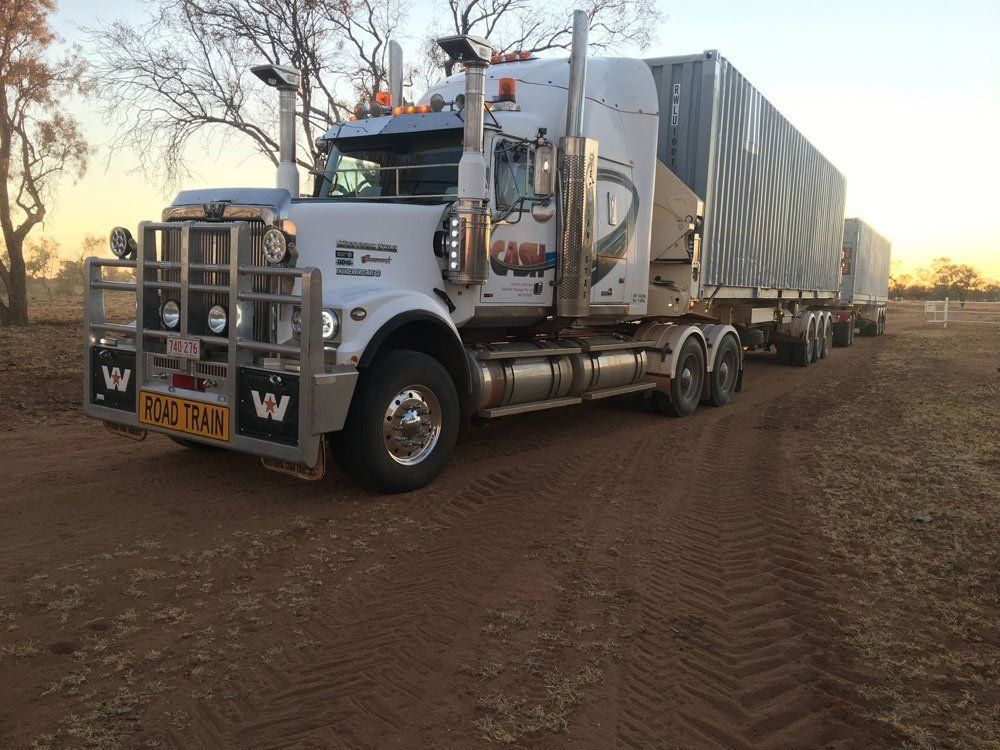 White Semi-Truck with Trailer on Dirt Road at Dusk — Central Australian Sidelifter Haulage in Ciccone, NT