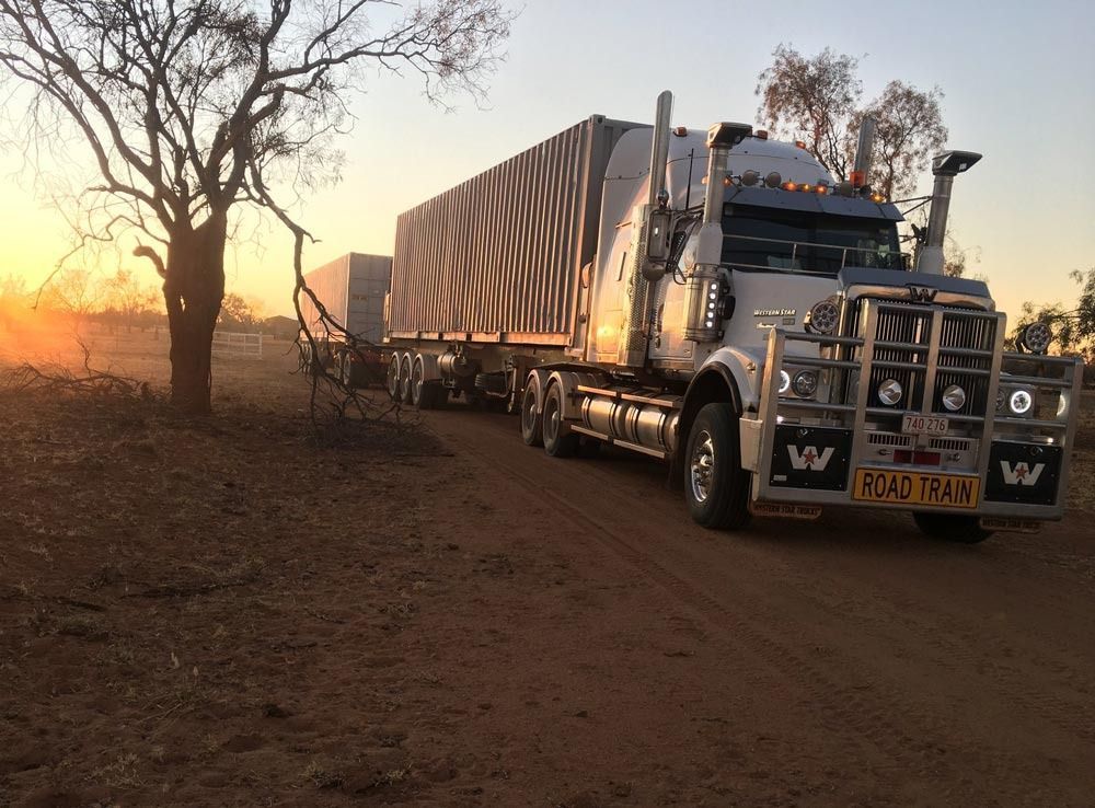 White Semi-Truck on A Dirt Road at Sunset — Central Australian Sidelifter Haulage in Ciccone, NT