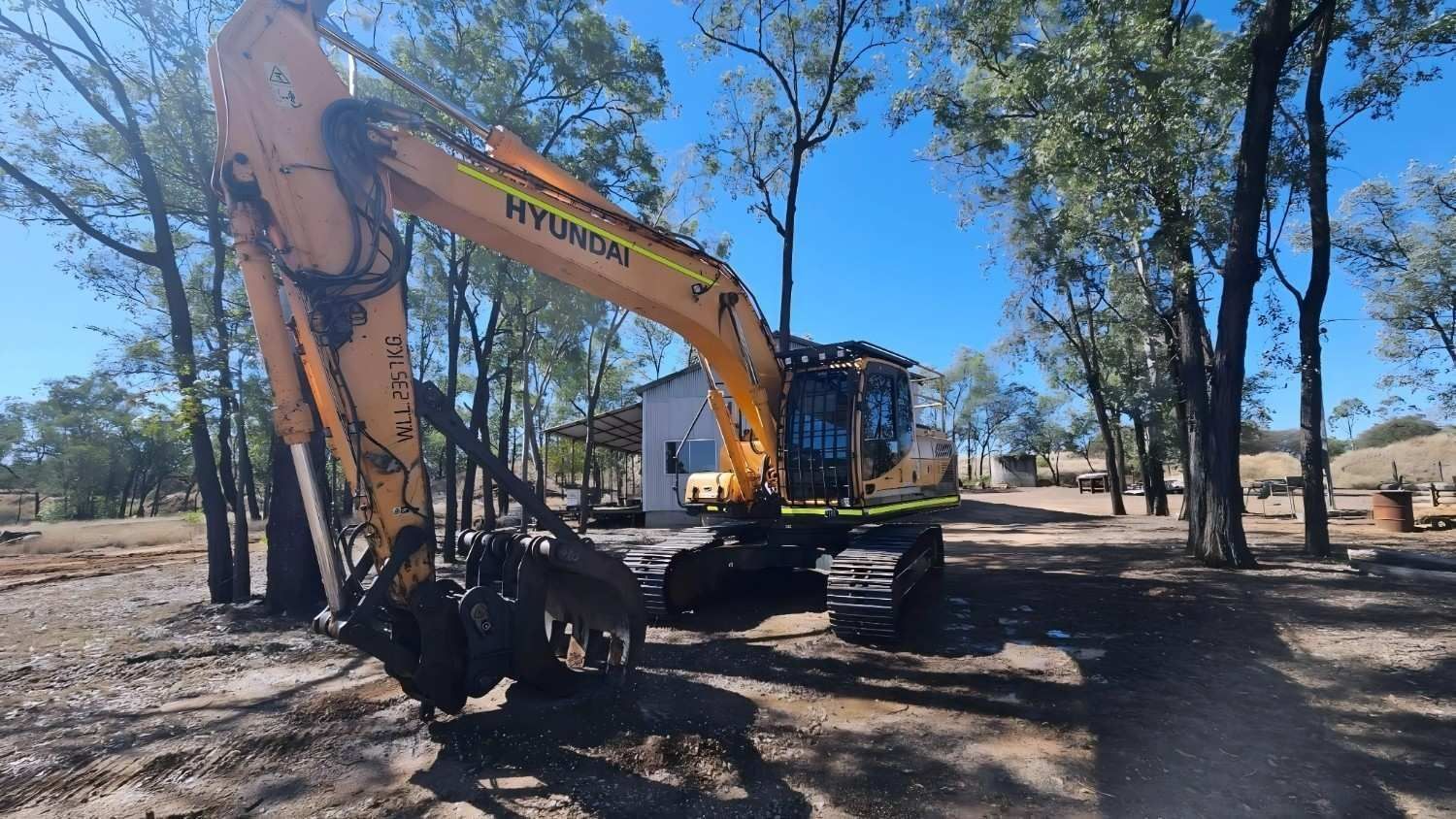 Yellow Hyundai Excavator in a Dry, Sunny Landscape, Near a Small Building — NPX Solutions In Gympie, QLD