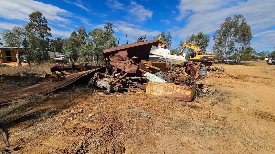 Demolished Rusty Structure With Excavator in a Dry, Rural Landscape Under a Blue Sky — NPX Solutions In Gympie, QLD