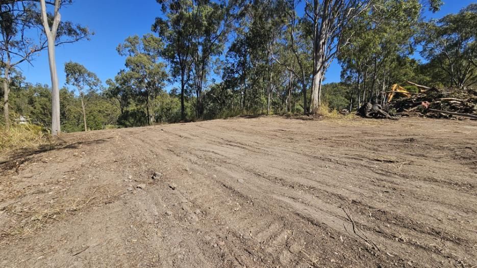 Dirt Road Clearing in a Forest With Tall Trees Under a Blue Sky — NPX Solutions In Gympie, QLD