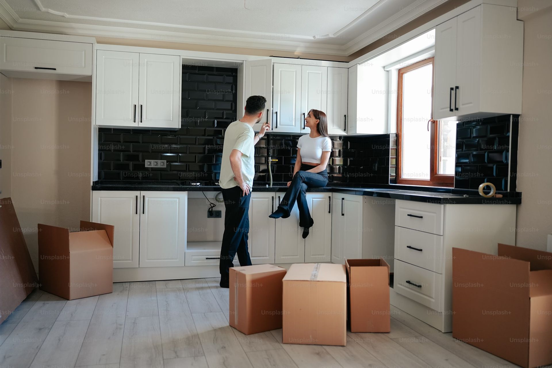 Couple unpacking boxes in new kitchen