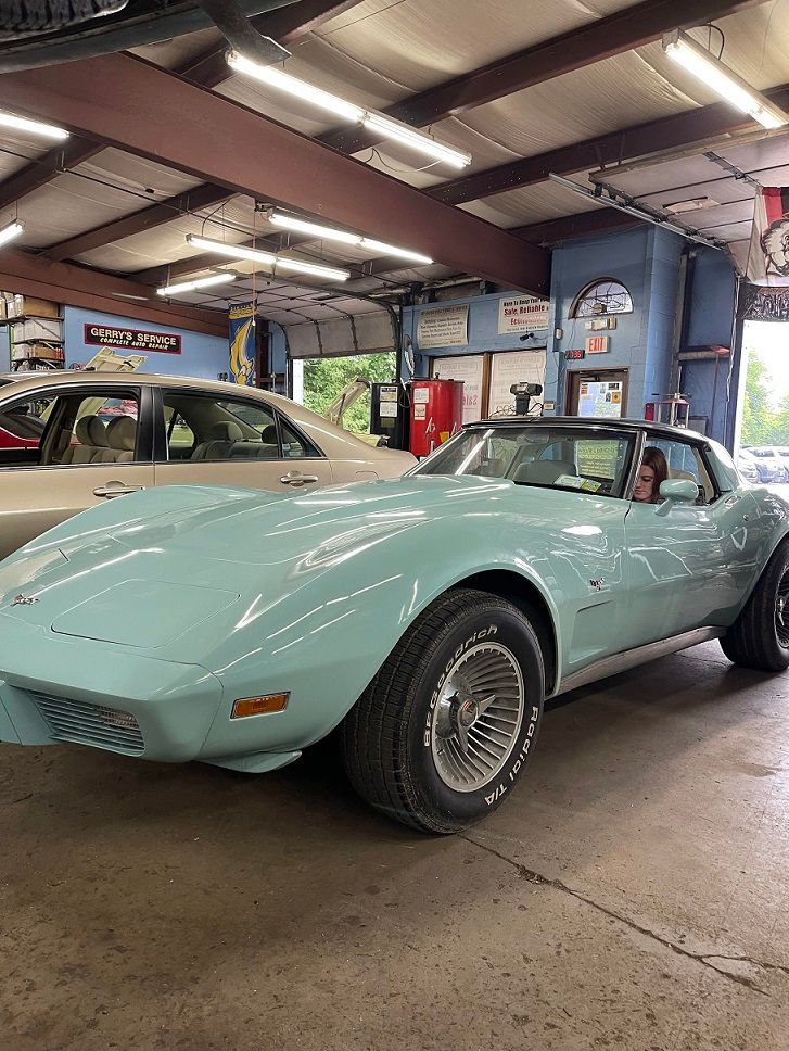 Light blue classic Corvette in a garage.