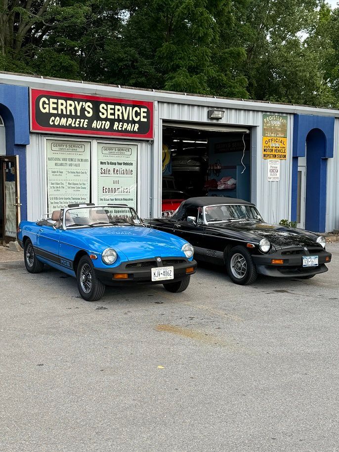 Blue and black convertible cars parked outside Gerry's Service, a complete auto repair shop.