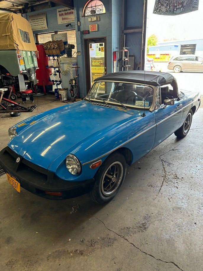 Blue convertible sports car inside a garage.